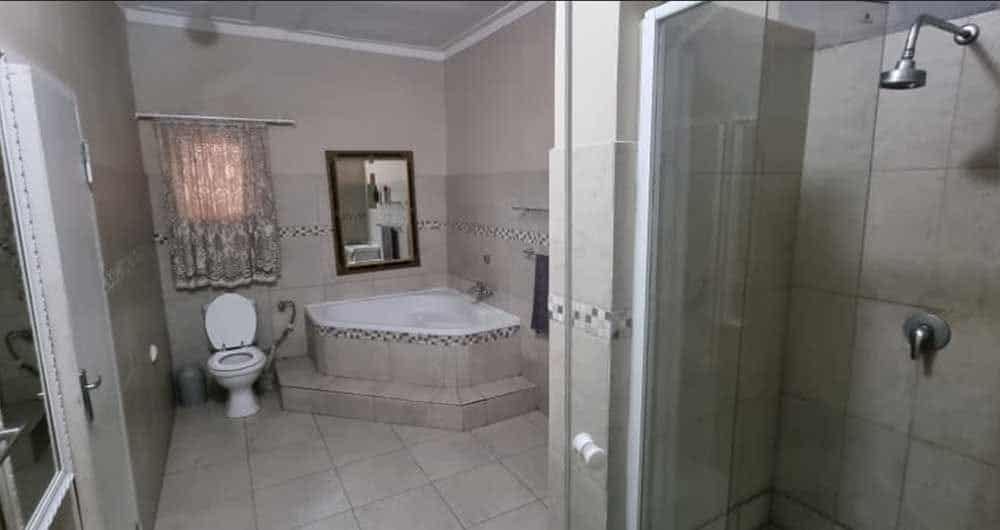 Bathroom with a corner bath, shower and towels