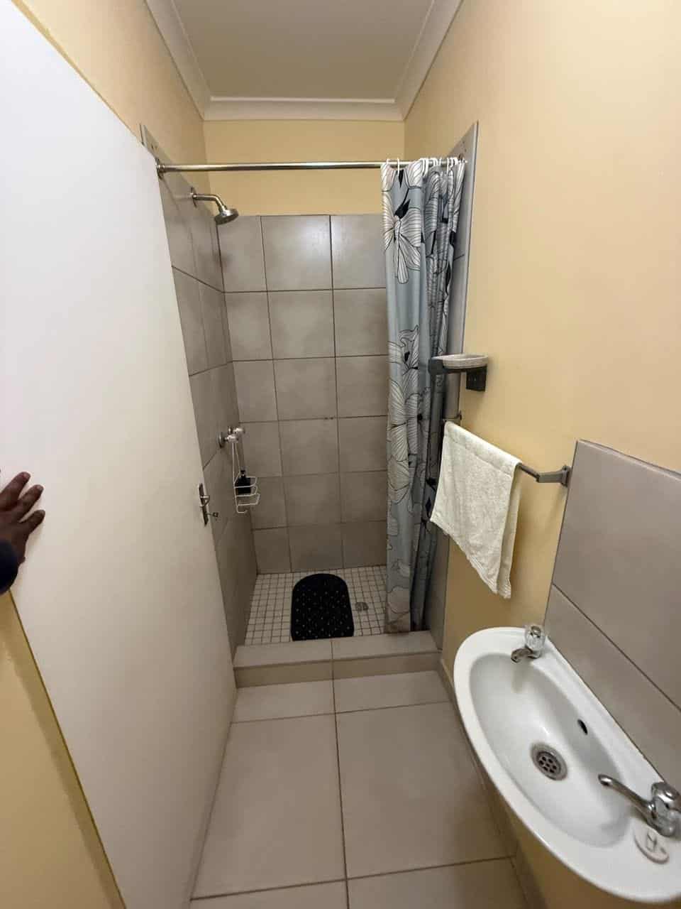 Tiled shower room with basin and mirror