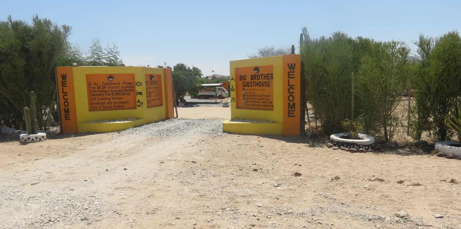 Yellow entrance gates with the welcome boards
