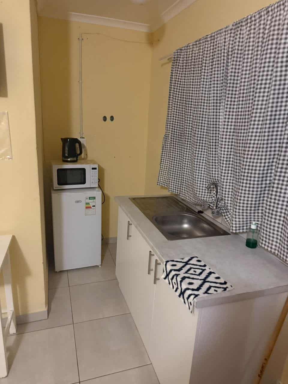 Kitchenette with sink, microwave and crockery