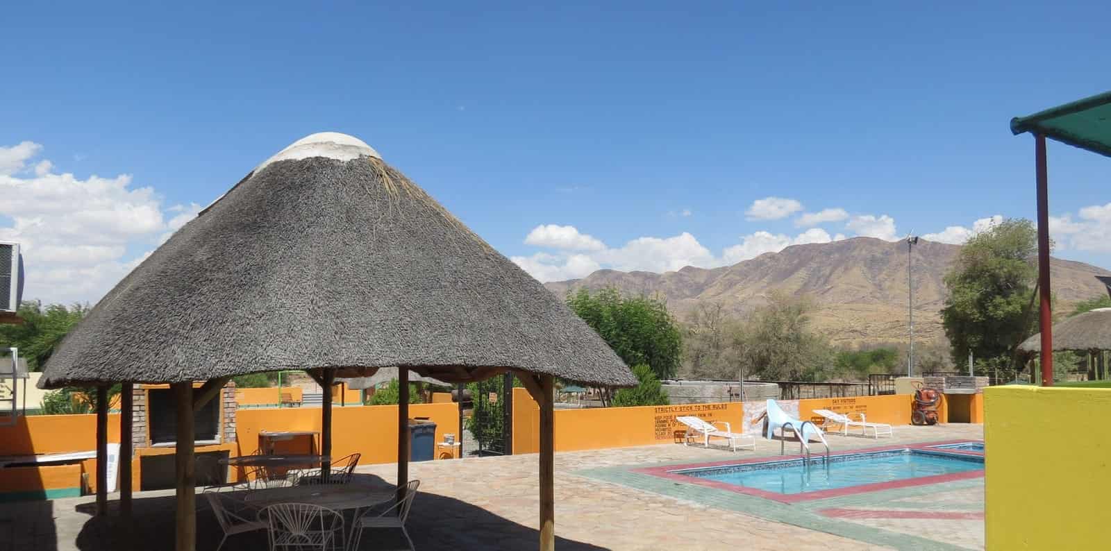 Thatched lapa and pool with the hills behind