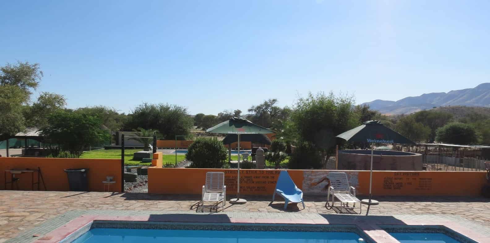 Pool with loungers and shade umbrellas against the hills