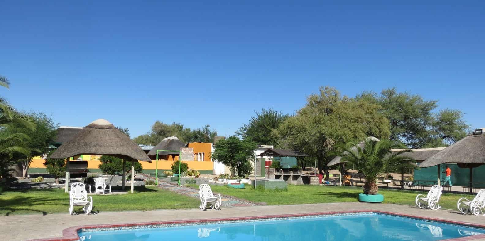 Pool with white loungers and thatch shade