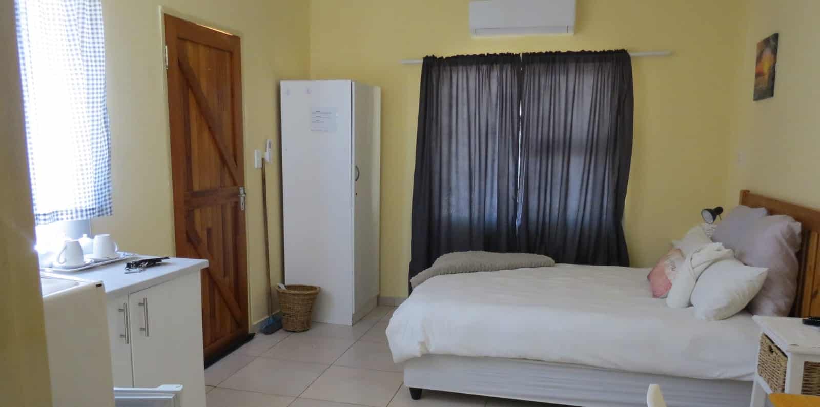 Double bed with kitchenette and wardrobe in the corner