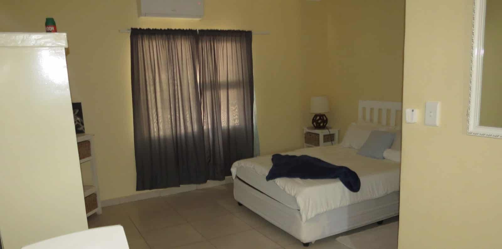 Single room with dark curtains and white linen