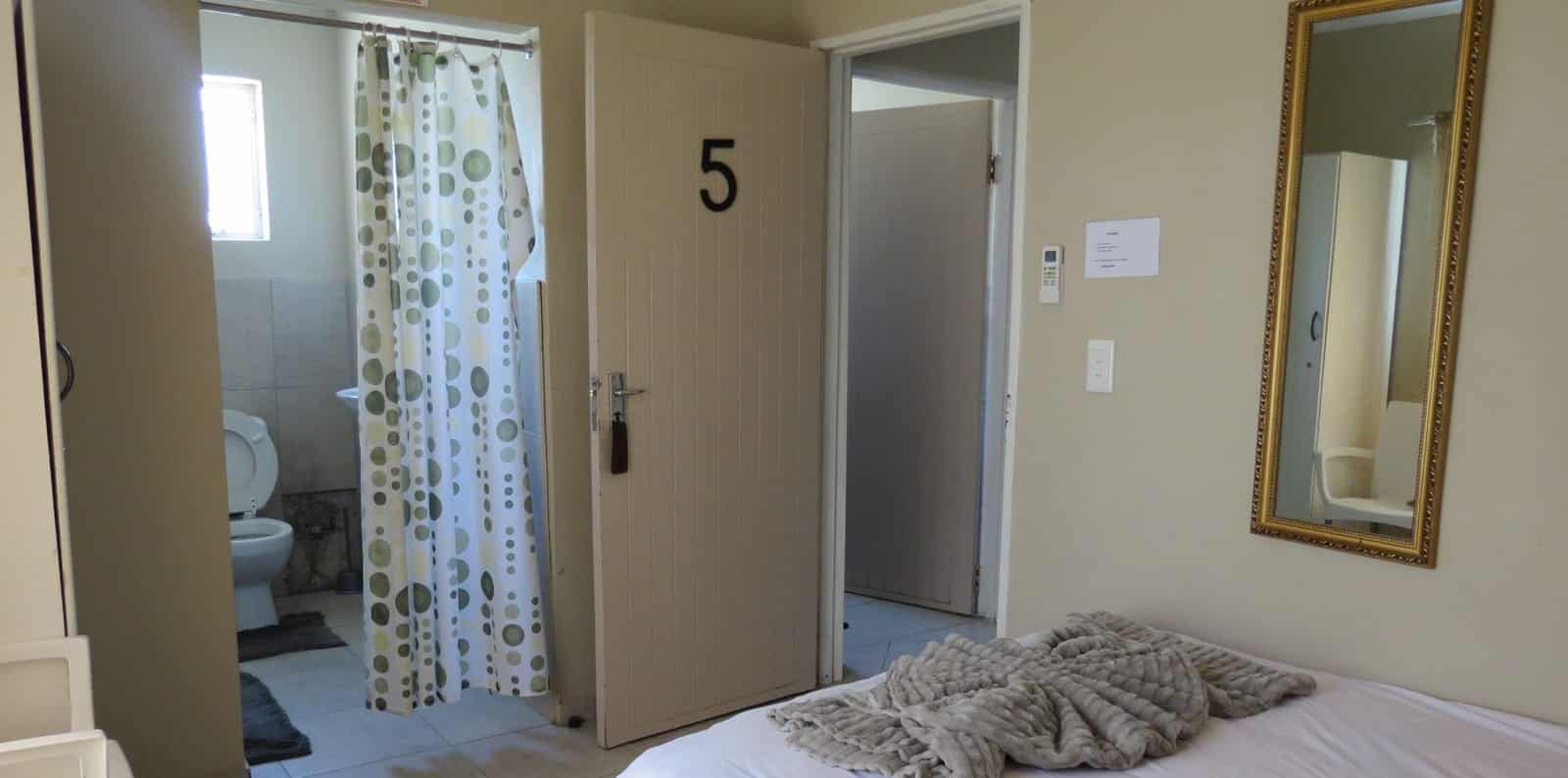 Single bed with a folded towel and wall mirror