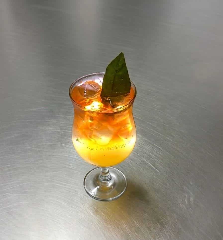 Orange cocktail with a fresh leaf