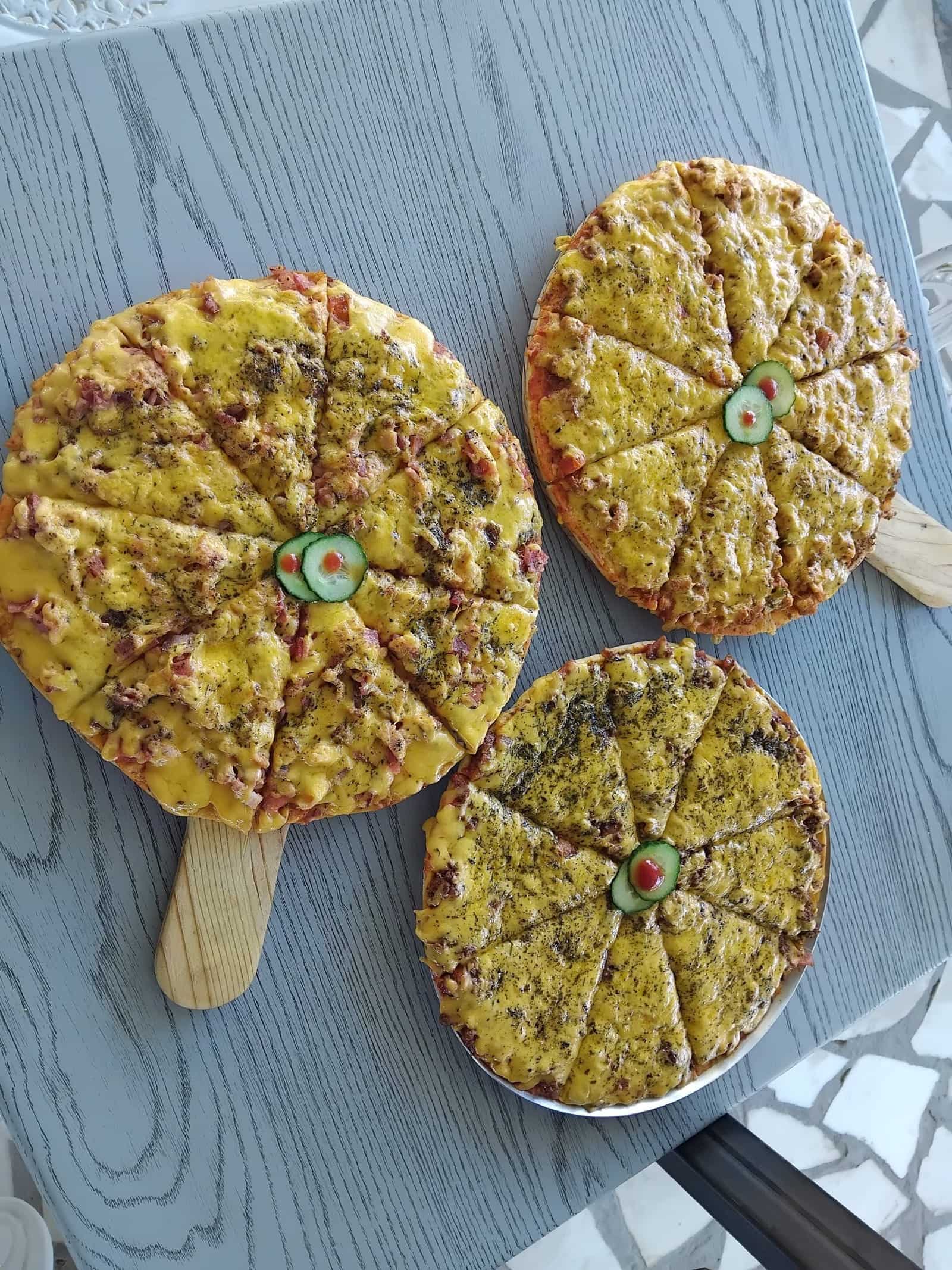 Three mini pancakes on wooden paddles