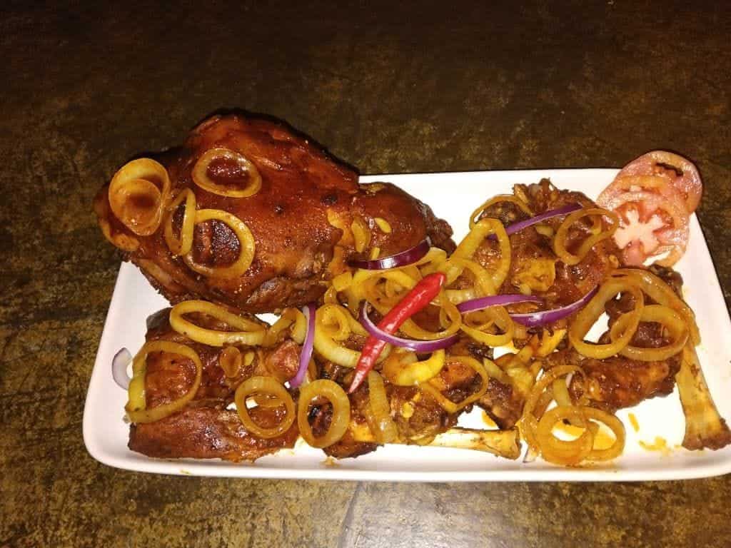 Carved chicken with onion rings on a platter