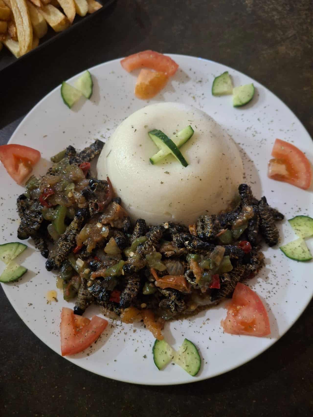 Mopani worms with pap, tomato and cucumber on the side
