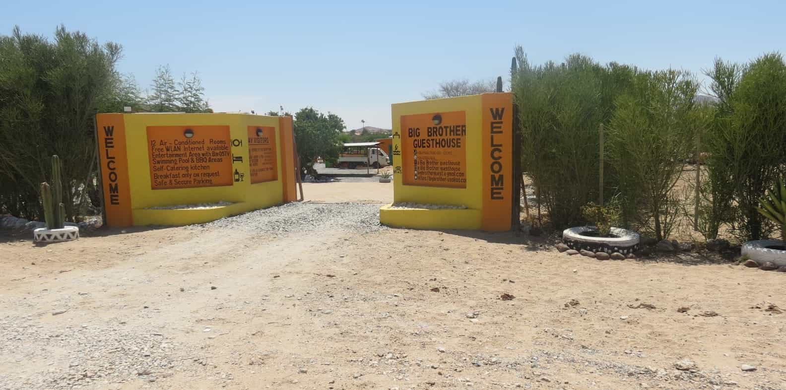 Yellow entrance gates with the welcome boards