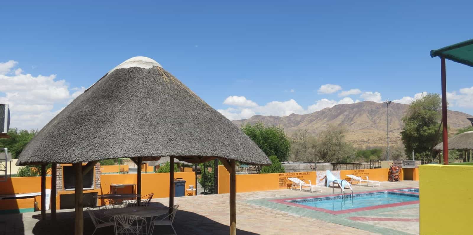 Thatched lapa and pool with the hills behind