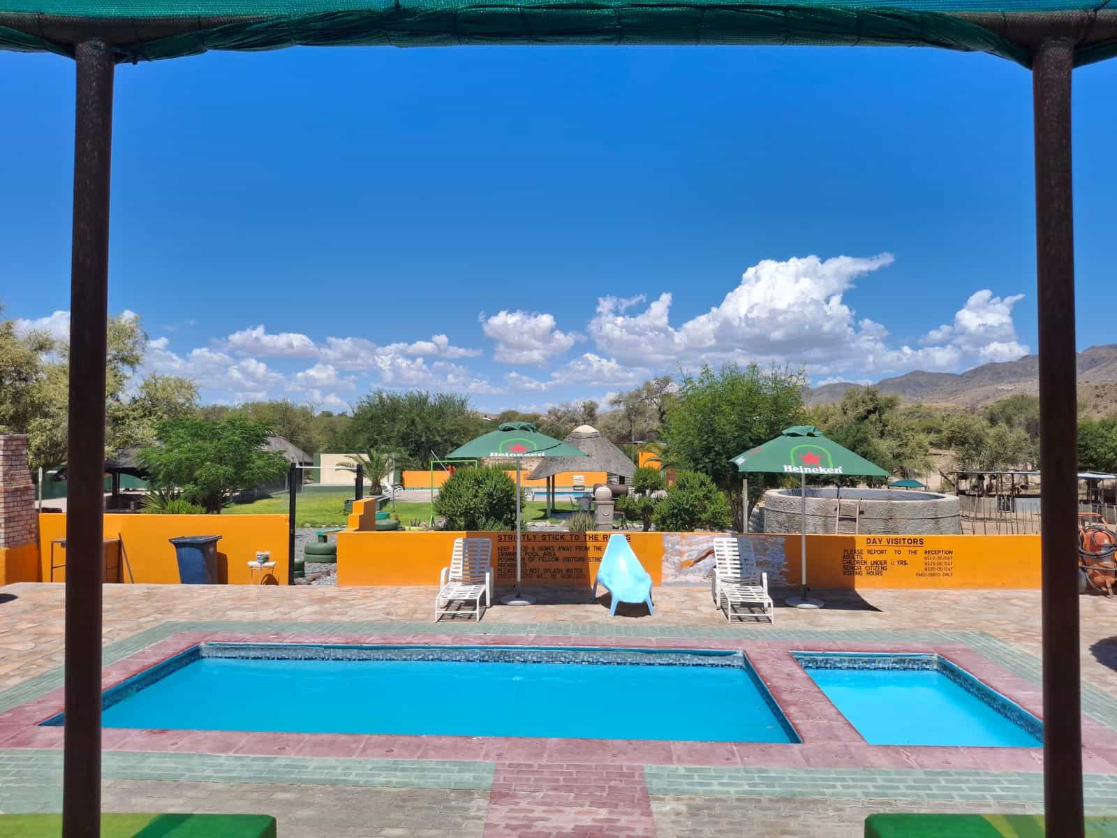 Swimming pool with umbrellas and thatched lapas